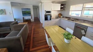 Un ambiente compatto con angolo ristoro, cucina e divano.