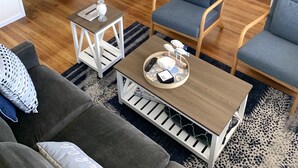 Ein Wohnzimmer mit Couch, Esstisch, blauen Stühlen und einem Holztisch.