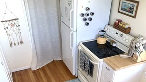 Eine kleine Küche mit Kühlschrank, Herd und Mikrowelle.