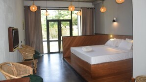 A bedroom with a wooden bed, wicker chairs, and hanging spherical light fixtures. - Mango Tree Villa Bentota (Induruwa)