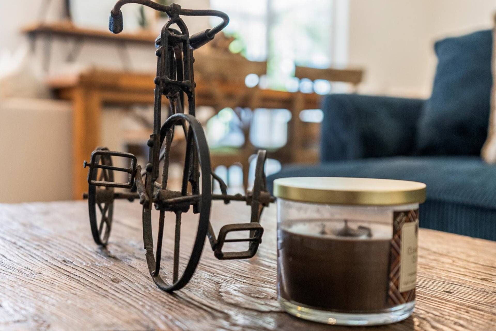 Uma bicicleta e uma vela sobre uma mesa de madeira.