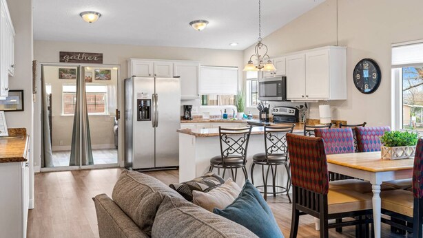 A spacious kitchen with a central island, stainless steel appliances, and a ceiling fan. - Private home near Zion & state parks, BBQ, cozy stay for family & friends in scenic red rock views! (La Verkin)