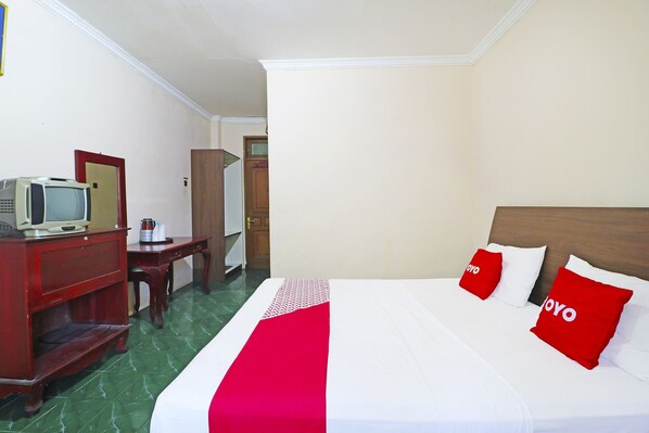 A hotel room with a bed, a desk, a television, and a wardrobe. - Hotel O Sarah Sukabumi (Sukabumi)