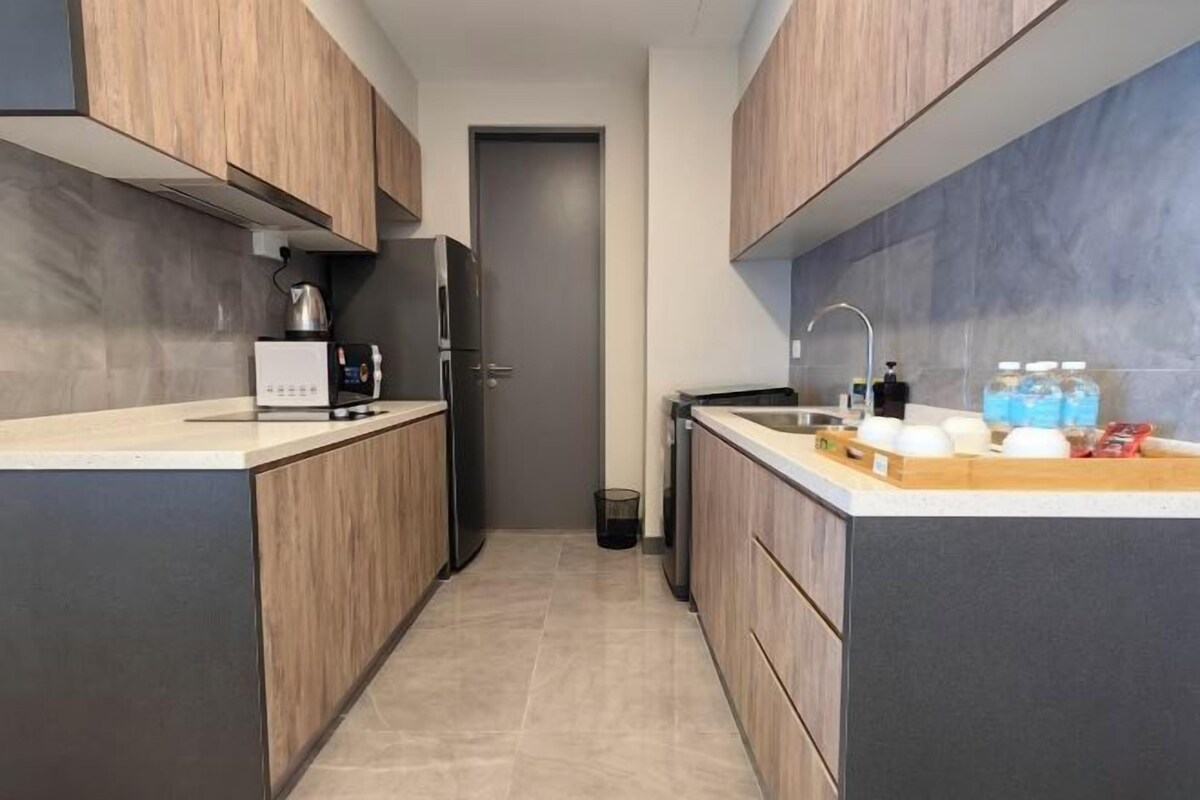 A modern kitchen with wooden cabinets, a built-in oven, a coffee maker, and a sink with a faucet.