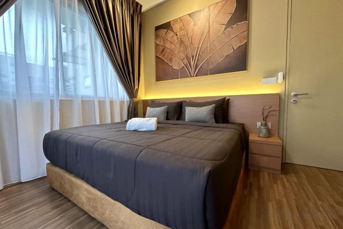 Una camera d'hotel con un letto grande, un comodino, un'opera d'arte appesa al muro e una porta.