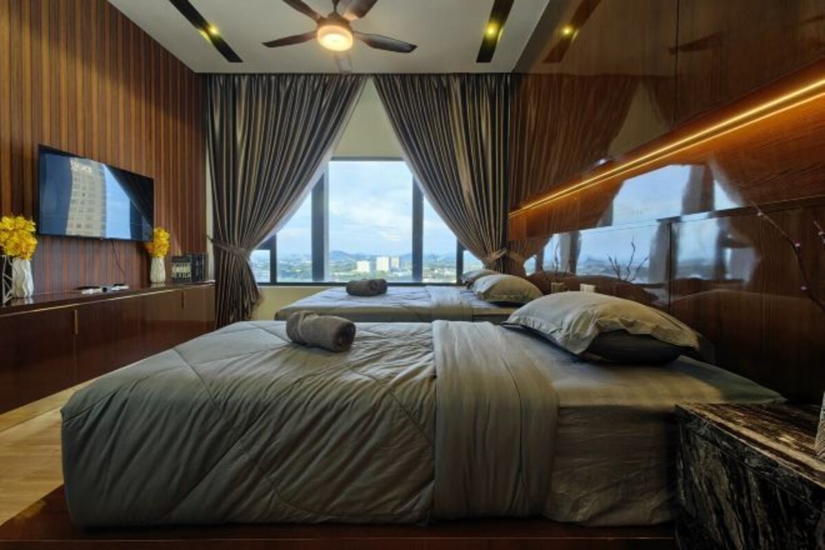 A modern bedroom with a large bed, a ceiling fan, and a city view through large windows.