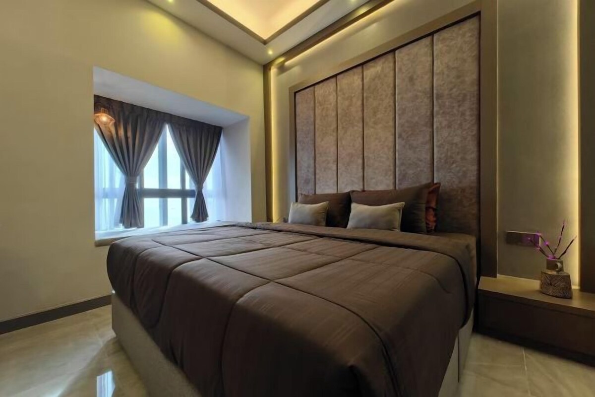 A modern bedroom with a large bed, a window with curtains, and a wall-mounted panel design.