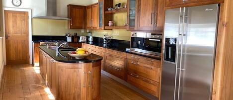 Kjøleskap, oppvaskmaskin, høy barnestol og spisebord