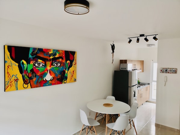 A modern kitchen with a refrigerator, microwave, and a 'Welcome Friends' sign.
