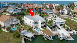 Zona residencial costera con casas, un muelle y una piscina.