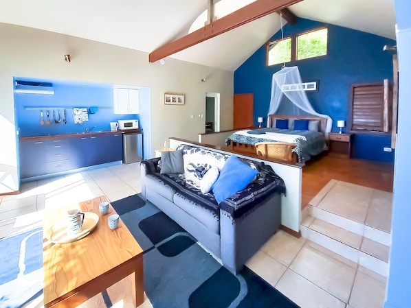 Um espaço compacto com cozinha compacta, sofá, cama e área de refeições.