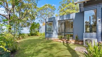A modern house with a well-maintained lawn and large windows.