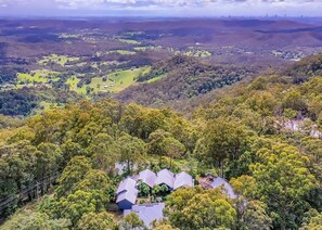 A panoramic view of a hilly area with a cluster of houses surrounded by dense forest. - Sky Island Studios (Clagiraba)