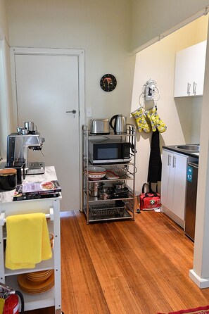 Eine kleine Küche mit Mikrowelle, Toaster, Wasserkocher und einem Schrank.