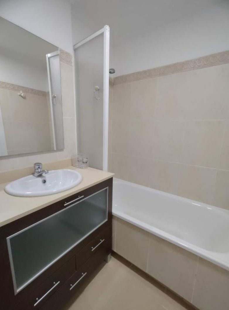 Un bagno con lavandino, specchio e vasca da bagno.
