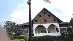 Un edificio con fachada de ladrillo, arcos blancos y techo triangular.
