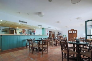 A restaurant with a counter and multiple tables and chairs. - Tugasa Hotel Sierra Y Cal (Olvera)