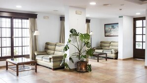 A spacious lobby with two sofas, a coffee table, and a potted plant.