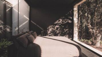 A modern bedroom with a curved bed, large windows, and a view of trees.