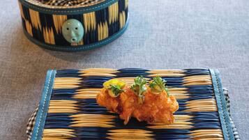 A woven basket with a checkered pattern containing a piece of food and a small decorative item.