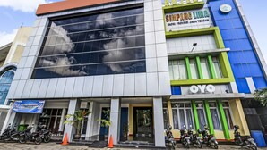 A hotel with a large glass facade, a prominent 'HOTEL SIMPANG LIMA' sign, and a 'YO' logo. - OYO 91036 Hotel Simpang Lima Gkpri (Semarang)