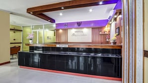 A hotel reception area with a reception desk, a "No Smoking" sign, and a reception sign. - OYO 91036 Hotel Simpang Lima Gkpri (Semarang)