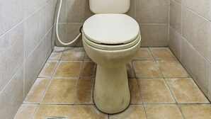 A small, enclosed bathroom with a toilet and a shower. - OYO 91036 Hotel Simpang Lima Gkpri (Semarang)