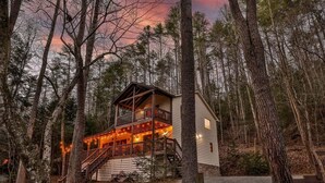 A cabin with a balcony, wooden deck, and a staircase leading to the entrance. - Chardonnay River Chalet| Ellijay, GA (Ellijay)