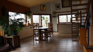 Una cocina amplia con comedor, armarios de madera y ventanas grandes.