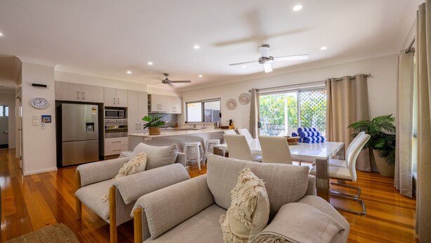 A modern kitchen with a refrigerator, oven, and microwave. There is a dining area with a table and chairs. - La Belle aimante, beautiful home with pool (HORSESHOE BAY)