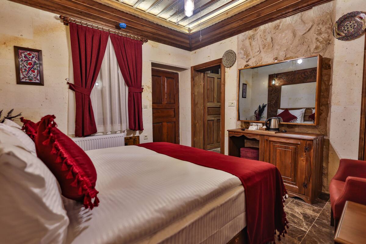 Un dormitorio con una cama grande, un armario de madera y un espejo.