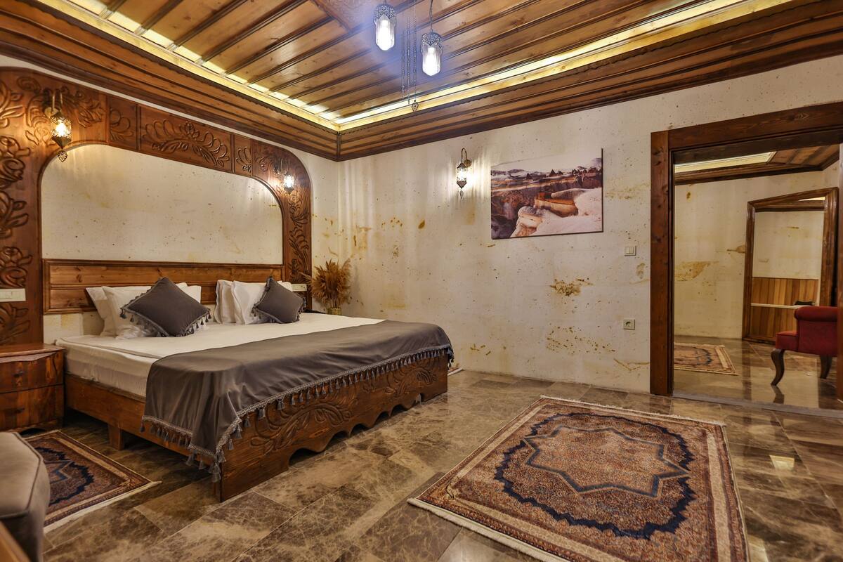 Un dormitorio con cama de madera, un espejo grande y un tapete estampado.
