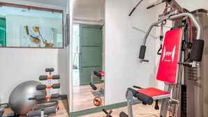 Une salle de sport équipée de matériel d’exercice, d’un grand ballon de gymnastique et d’un miroir au mur.