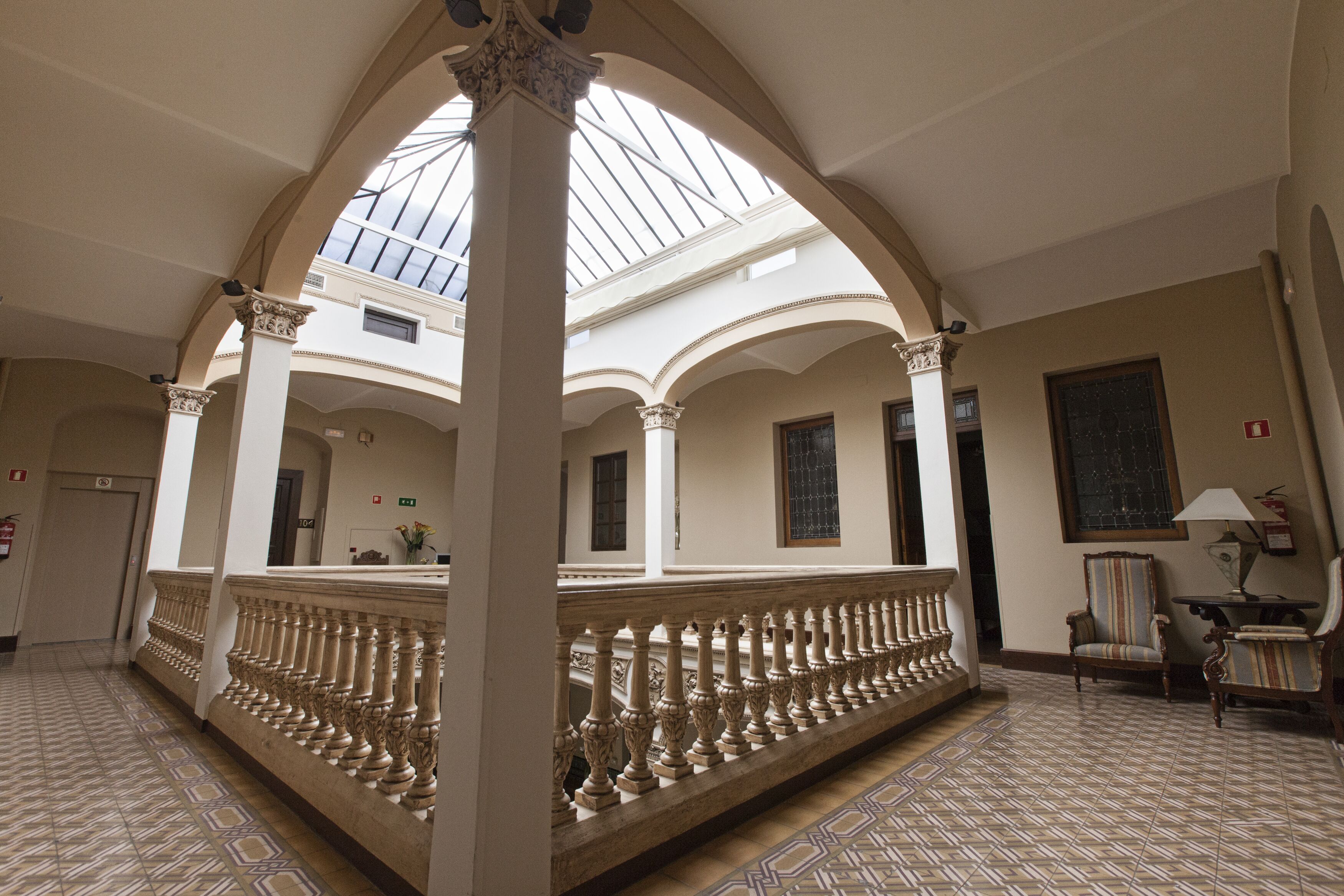 Een ruim interieur met een hoge plafond, een centrale kolom en een patroon vloer.