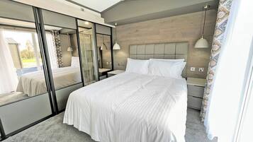 Une chambre avec un grand lit, un miroir, une table de chevet et une fenêtre.
