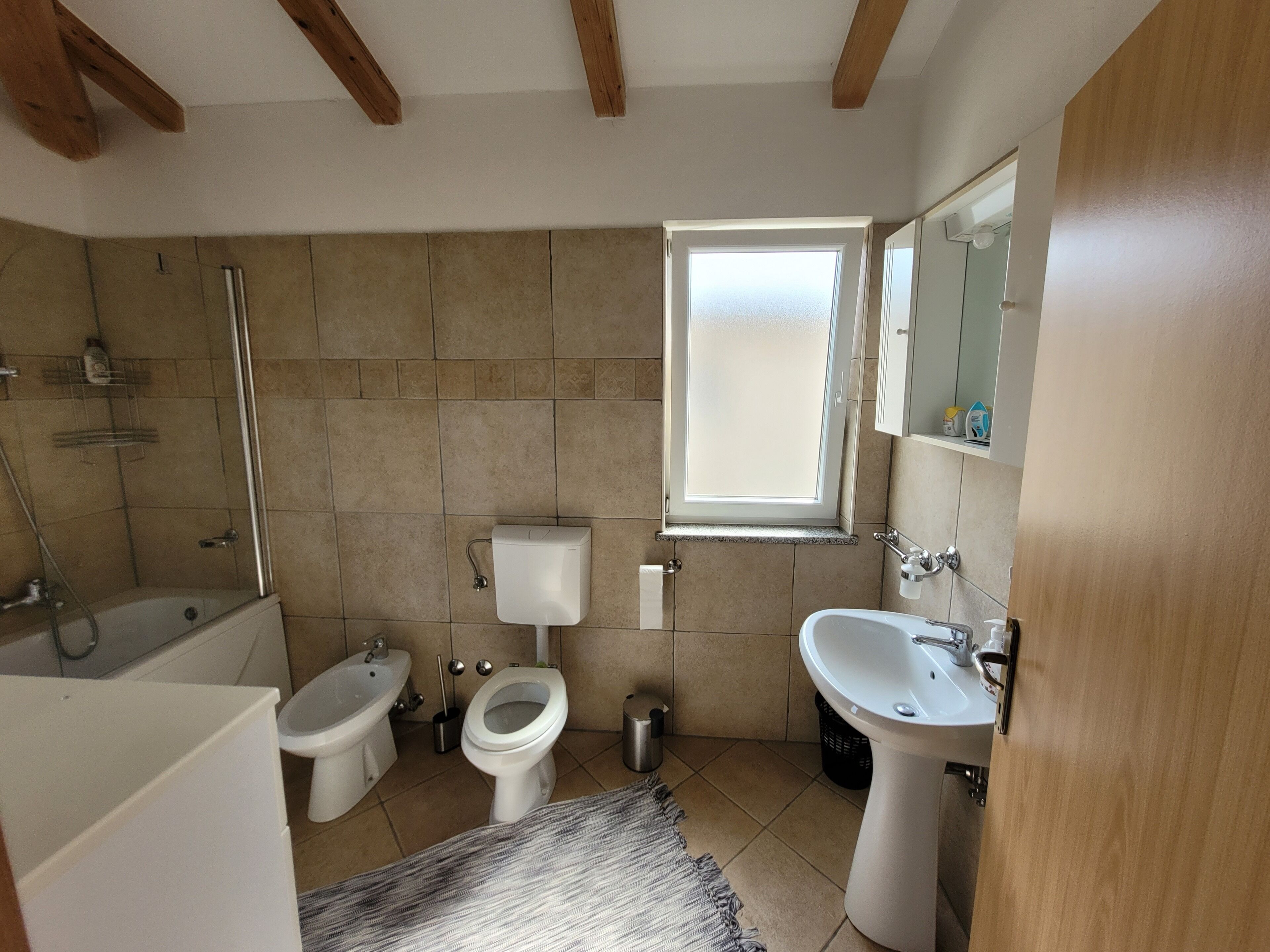A bathroom with a bathtub, toilet, bidet, and sink.