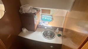 A compact bathroom with a toilet, sink, and shower. - Bateau à Quai (Sainte-Maxime)