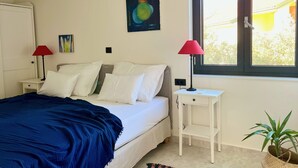 A bedroom with a bed, two bedside tables, a window, and a painting on the wall. - Penthouse apartment (Šimuni)