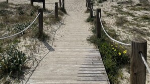 A wooden boardwalk leading to the beach with a clear sky and ocean in the background. - Apartment SON BOU, 67 (Son Bou)