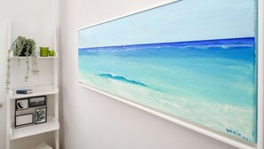 Una pintura de una escena de playa en una pared.