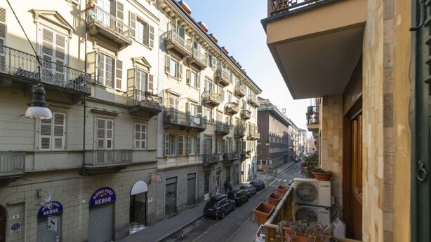A street view with multi-story buildings, balconies, and parked cars. - GuestHost - Porta Nuova Mini Flat 2 New! (Torino)