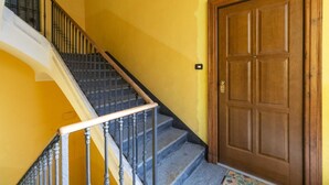 Una escalera con baranda de madera, baranda de metal y una puerta de madera.