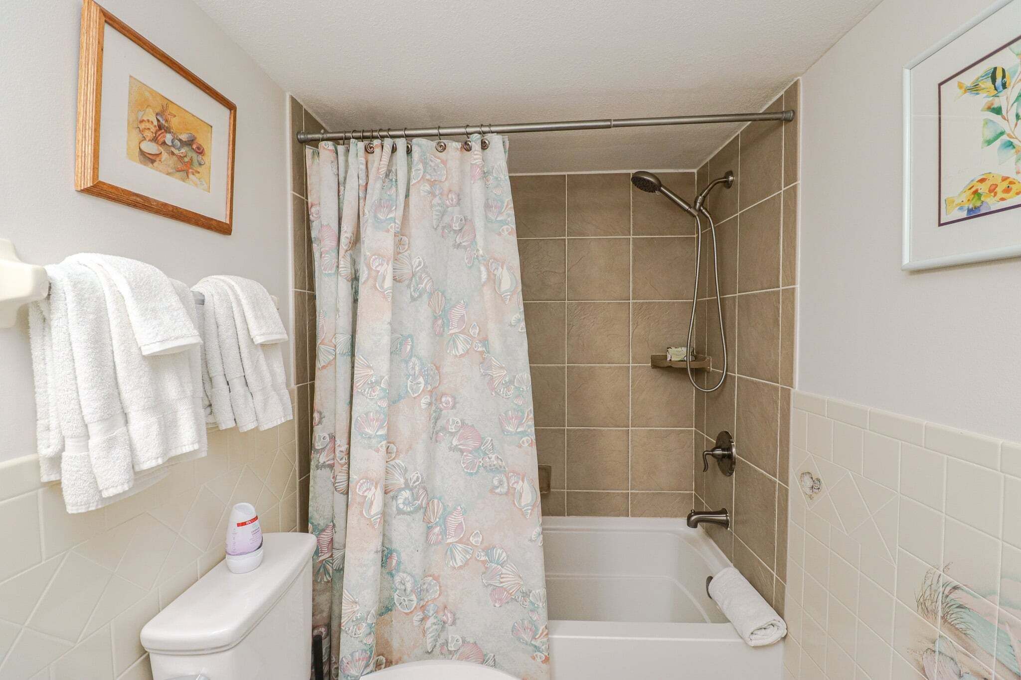 A bathroom with a shower, toilet, and bathtub.