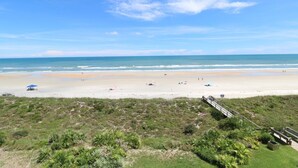 A beach with a wooden walkway leading to the shore, a sandy beach, and a clear blue sky. - Sand Dollar 1-504 - 5th Floor Ocean Front Condo in St. Augustine! (St. Augustine)