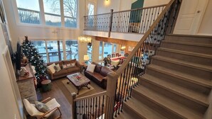 A spacious living area with a staircase, a Christmas tree, and a dining area. - CAN-Luxury cottage by the water (Severn Bridge)