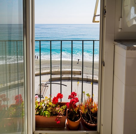 A balcony with a view of the beach and the ocean.