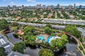 Residents enjoy a serene atmosphere with a pool surrounded by lush greenery and a water feature, offering a clear view of the ocean.