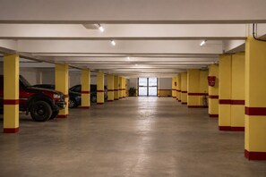 A parking garage with yellow pillars and a concrete floor. - Loli Home Agadir - Bay Premium Pool (Agadir)