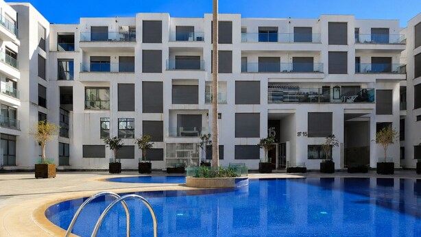 A modern building with a swimming pool in front. - Loli Home Agadir - Bay Premium Pool (Agadir)