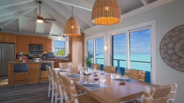 Una cucina moderna con zona pranzo, ampie finestre e vista sull'oceano.